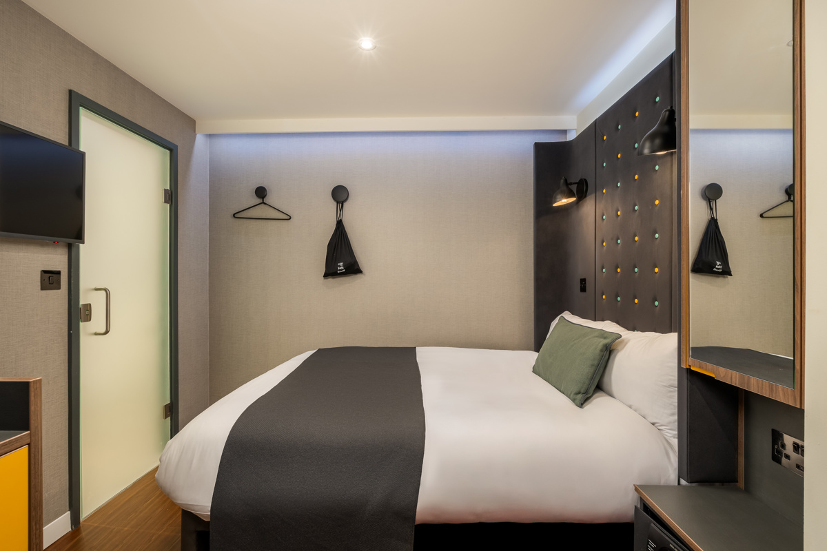Cozy double bedroom featuring a comfortable bed with pillows and soft lighting at Point A Hotel Paddington