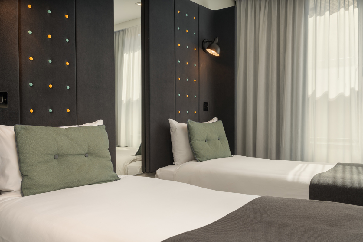 Cozy double bedroom featuring a comfortable bed with pillows and soft lighting at Point A Hotel Paddington